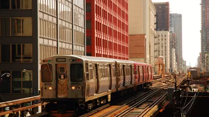 CHicago elevated train on track passing by tall buildings.