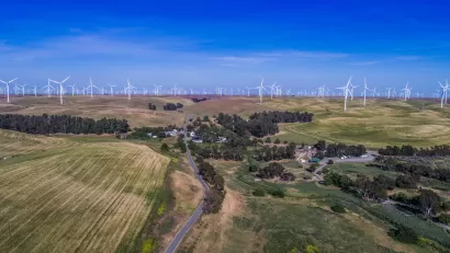 Aerial view of small community among green agricultural fields and wind turbines in Solano County, Northern California.