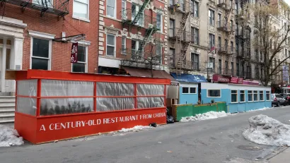 Row of outdoor dining kiosks in New York City during Covid-19 in winter. Kiosks are enclosed with plastc or plexiglass.