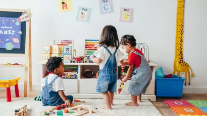 Three toddlers playing in a colorful playroom