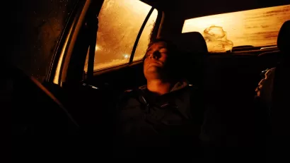 Person sleeping in car at night.