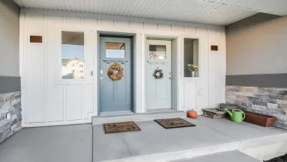 Two pastel green/blue front doors on duplex with decorative wreaths.
