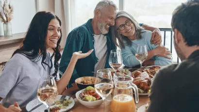 Multi-generational white family sits around dining table