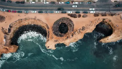 Bird's eye view of coastal erosion next to a roadway in Sunset Cliffs, California.