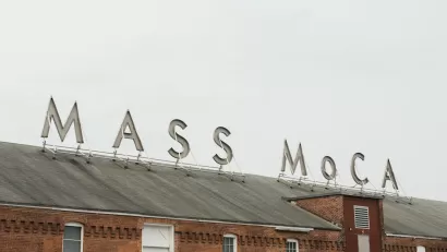 Sign for MASS MoCA on brick building.