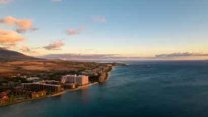 Aerial view of coast in Maui, hawaii with hotels and condo buildings at sunrise or sunset.