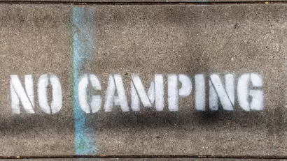 "No Camping" stencil on concrete.