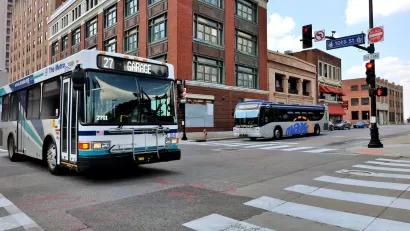 City bus in downtown Kansas City with brick buildings in background.