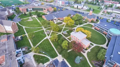 Aerial view of college campus with red brick buildings and green lawns.