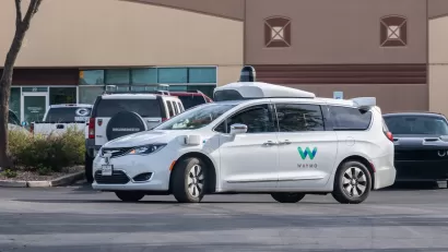 White Waymo self-driving car in parking lot in Chandler, Arizona.