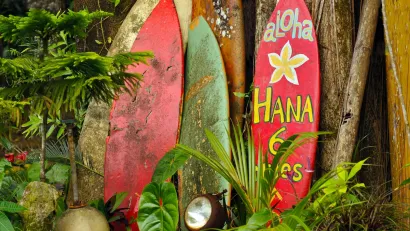 Red and yellow surfboards leaning against fence in Maui, Hawaii.