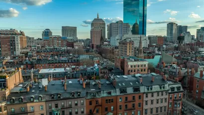 Aerial view of downtown Boston, Massachusetts with older buildings in foreground and modern glass towers in background.