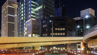 Vacant pedestrian overpass and skyscrapers in downtown financial district at night.