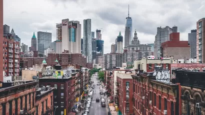 View of brick buildings and One World Trade Center building and New York City skyline.