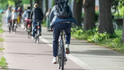 People riding bikes on a paved bike trail.