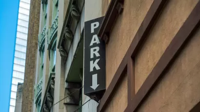 Close-up of vertical PARK sign on multistory urban parking garage.
