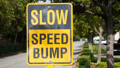 Yellow and black "SLOW SPEED HUMP" sign on residential street