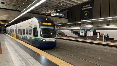 White and blue Seattle Link light rail train pulling into station in Seattle, Washington.