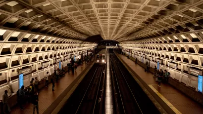 View from above platform in D.C. Brutalist subway station with people waiting on platforms