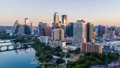 View of Austin, Texas skyline with river in foreground during morning golden hour.