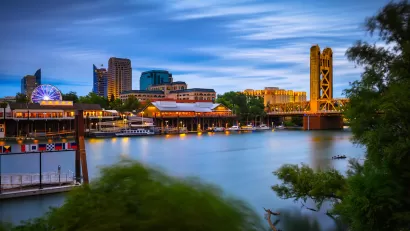 Nighttime view of Sacramento River with Tower Bridge and Sacramento skyline.