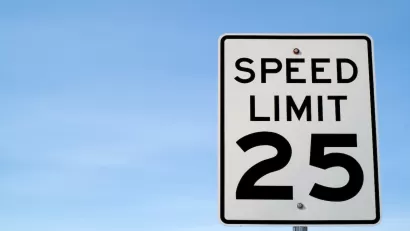 CLose-up on black and white 25 mph speed limit sign.