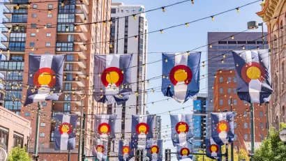 Colorado flags draped between buildings in downtown Denver, Colorado.