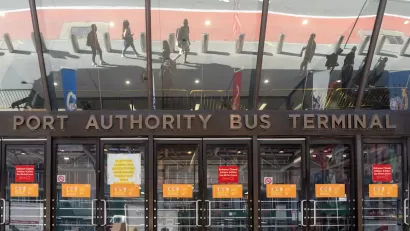 Entrance to Port Authority Bus Terminal with glass doors and sign in midtown Manhattan, New York City.