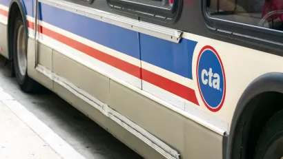 Close-up of side of white and blue and red Chicago Transit Authority bus.