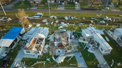 Aerial view of heavily damaged mobile homes after a hurricane in Florida.