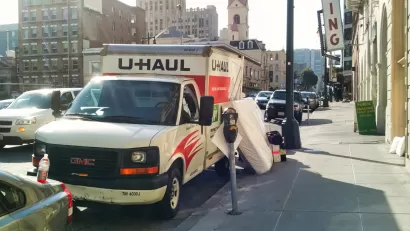 U-Haul moving van parked by a curb in San Francisco with mattress leaning against it
