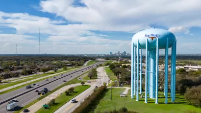 Aerial view of freeway and large blue water tower with Fort Worth logo on it in Fort Worth, Texas.
