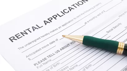 Close-up of rental application laying on table with green pen laying across the paper