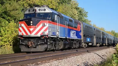 Chicago Metra heavy rail commuter train on track with trees in background.