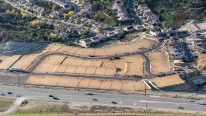 Aerial view of new neifhborhood under construction with enpty lots in foreground.