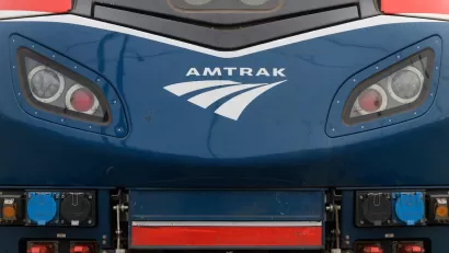 Close-up of front of blue locomotive with Amtrak logo.