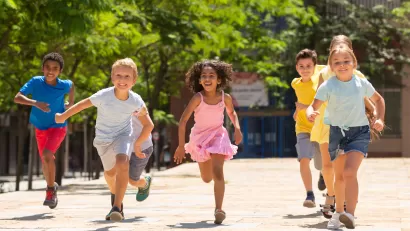 Group of children running outdoors toward camera.