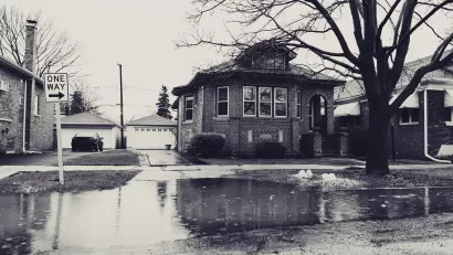 Sepia-toned photo of flooded street with residential home
