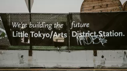 Black banner with white text "We're building the future - Little Tokyo/Arts District Station" in Los Angeles, California.