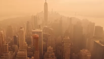 Aerial view of New York City including Empire State Building blanketed in orange wildfire smoke