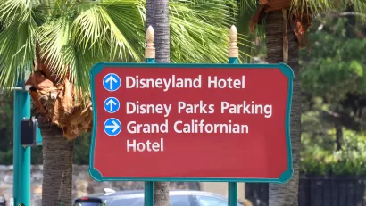 CLose-up of red outdoor sign for Disneyland Hotel, Disney Parks Parking, and Grand Californian Hotel in Anaheim, California.