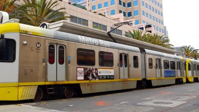 Yellow and silver light rain train in downtown Long Beach, California.