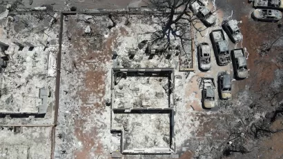 Aerial view of destroyed home and cars after Lahaina, Hawaii wildfires.