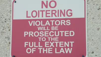 Red and white "No Loitering" sign.