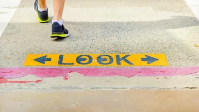 Close-up of "LOOK" sign on sidewalk with one pedestrian walking away.