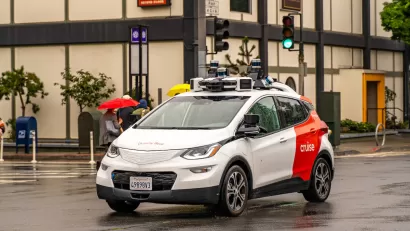 White and red Cruise autonomous car on San Francisco street.