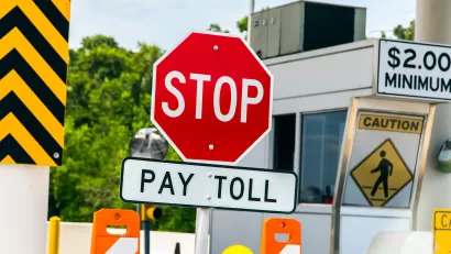 Freeway toll booth with "Stop" and "Pay Toll" signs