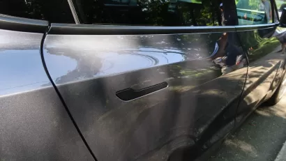 Close-up of door handle on outside of grey Tesla electric car.