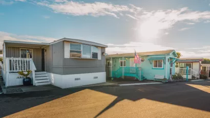 Row of colorful mobile homes on an asphalt street.