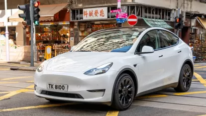 White Tesla sedan on street in Hong Kong.